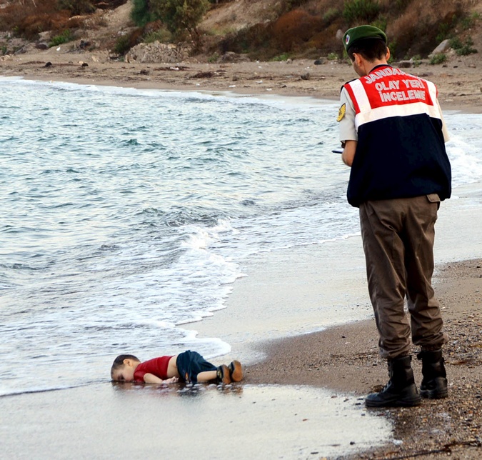 Турецкий полицейский возле утонувшего мальчика. 