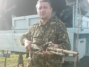 Поисковик Василий Панасенко держит пулемет, который на черном рынке оценивается в 2 тысячи долларов. 